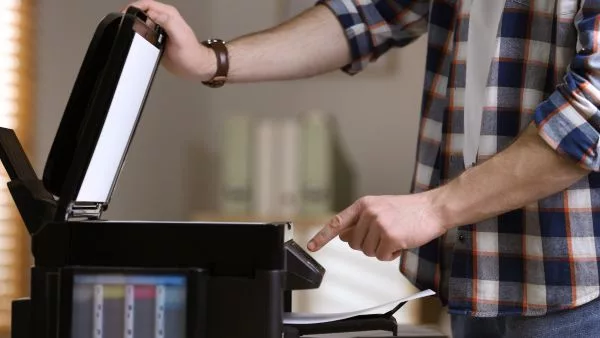 homem configurando impressao de materiais na impressora